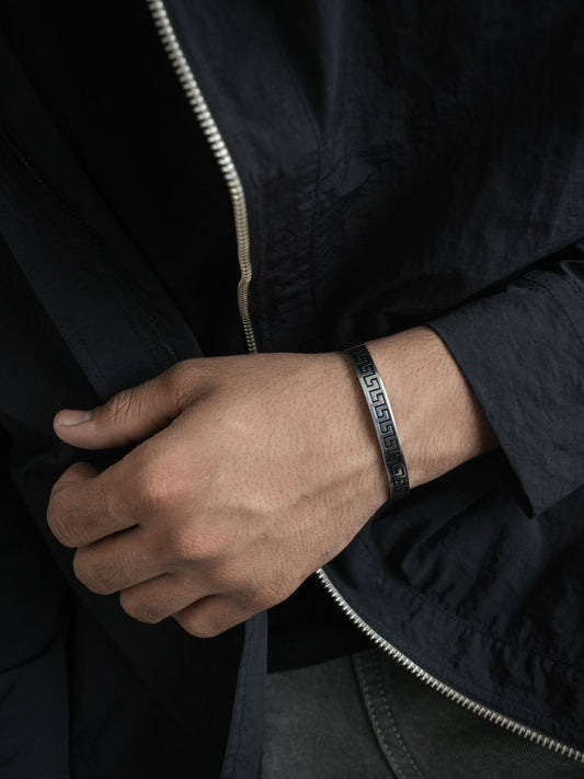 Hand wearing a bracelet with a dark background